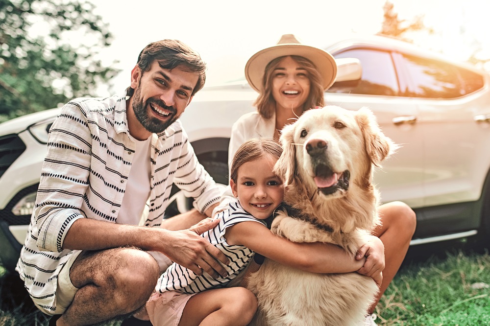 Una famiglia con il cane in campagna: pronti per le vacanze