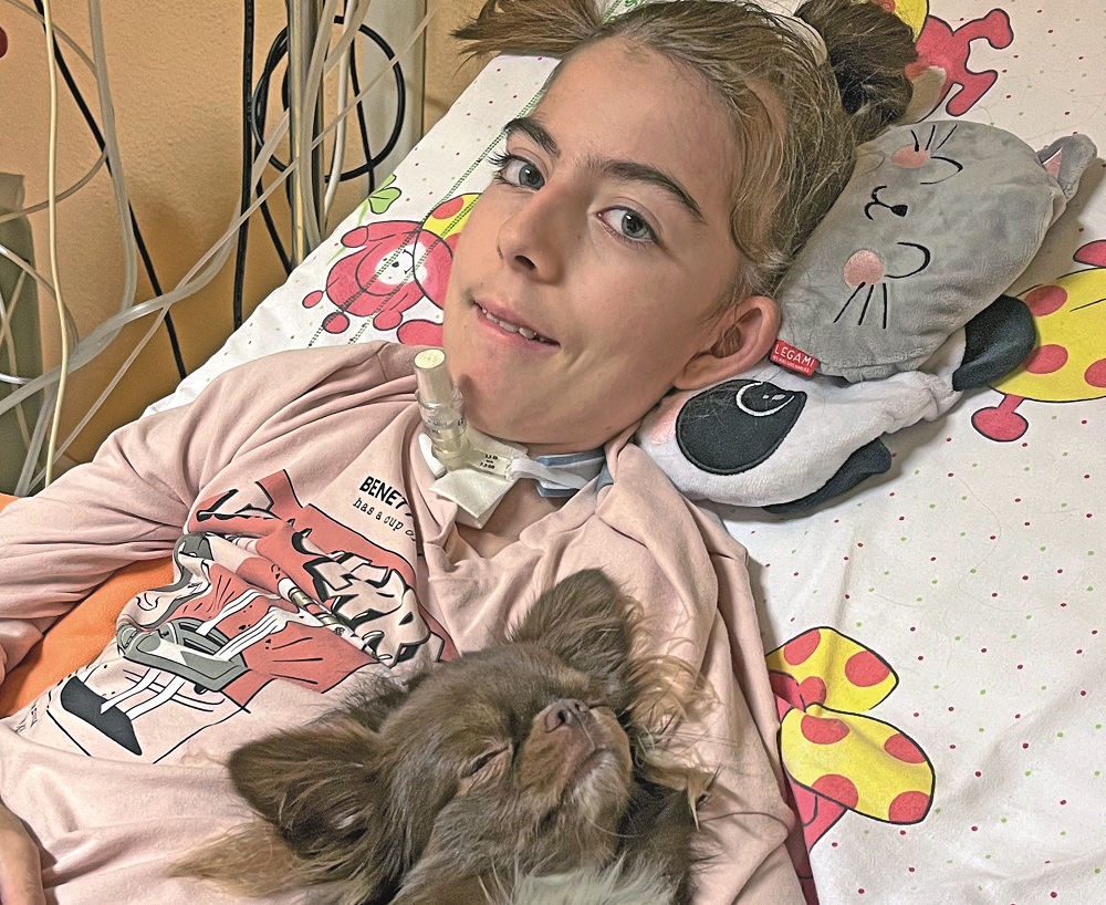 Melissa insieme al suo cane da supporto emotivo Kinder, distesi a letto