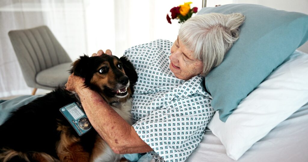 Una anziana ricoverata abbraccia il suo cane: un esempio di come funzionerà il villaggio che ospiterà i cani dei degenti ospedalieri a Genova