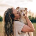 Una donna abbraccia il suo cane all'aperto: il Pet Day 2026 festeggia il legame uomo-animale