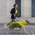 Una donna corre con il suo cane vestito con una mantella dell'azienda Cloud7: il brand è presente all'inaugurazione del nuovo Pet Design District a Milano